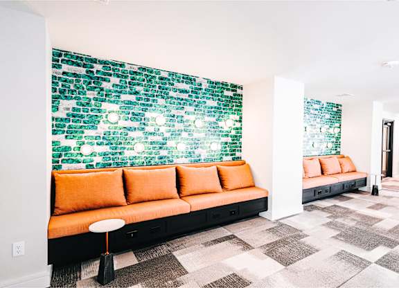 a living room with orange couches and a green wall