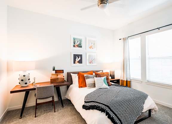 a bedroom with a bed and a desk with a chair