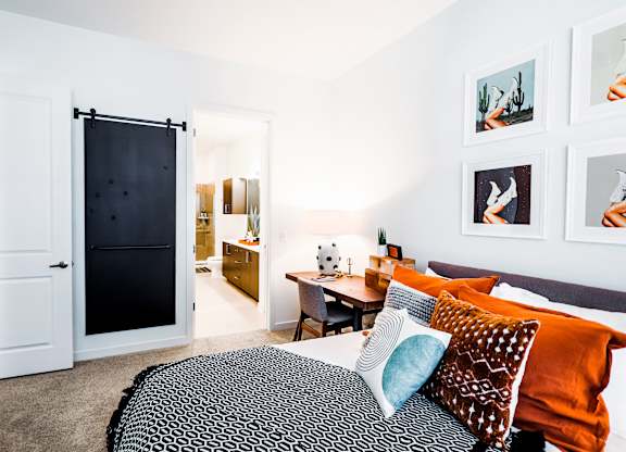 a bedroom with a bed and a desk and a bathroom