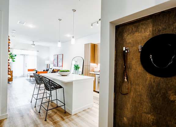 a kitchen and dining room with a white island and bar stools