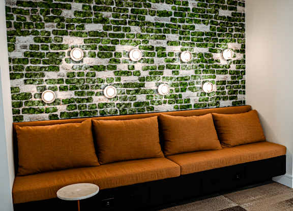 a living room with a couch and a green wall with lights on it