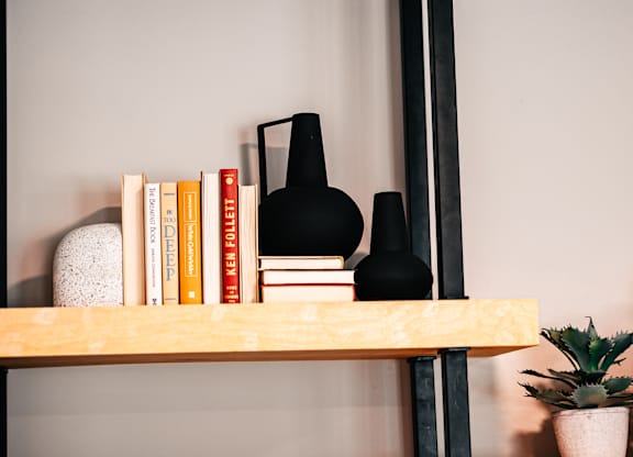 a bookshelf with books and a black lamp on it