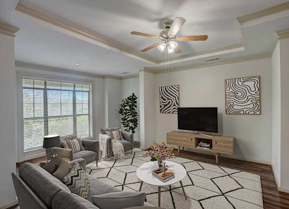 a living room with a ceiling fan and a television