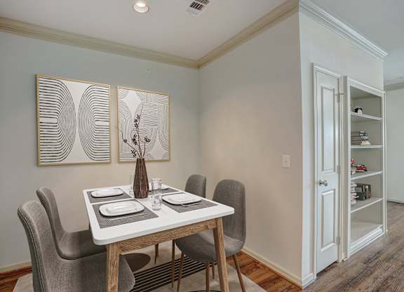 a dining room with a table and chairs and a door to a closet