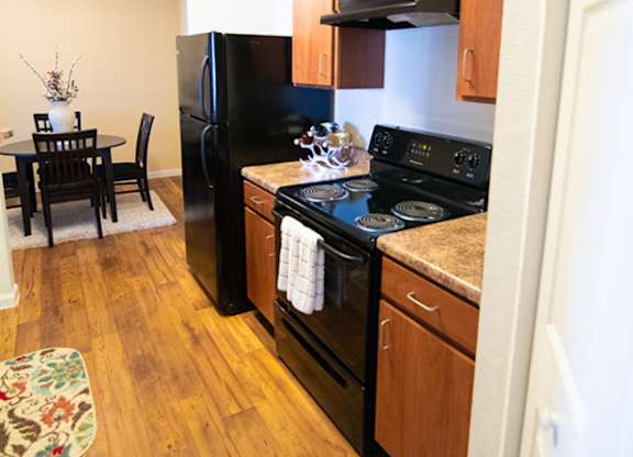 A kitchen with wooden cabinets and black appliances.
