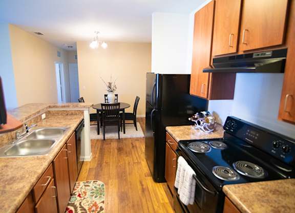 A kitchen with wooden cabinets and a black stove top oven.
