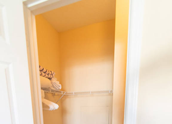 A white door is open to a hallway with a carpeted floor.