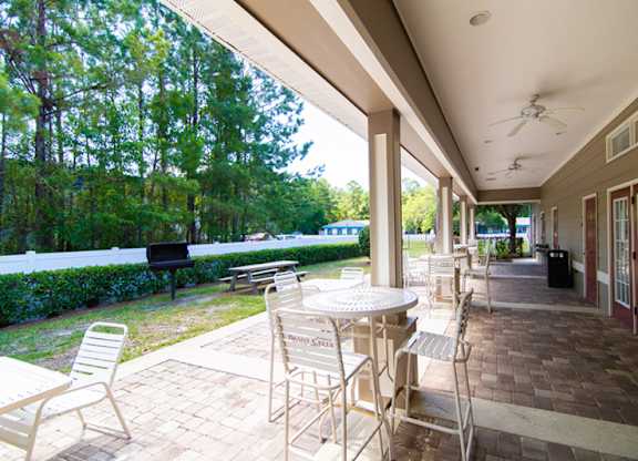 A patio with a table and chairs is covered by a roof.