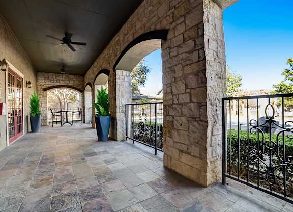 A patio with a stone floor and a black metal railing.