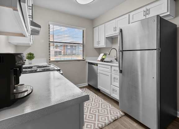 an open kitchen with stainless steel appliances and white cabinets