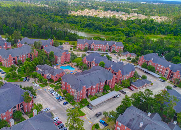 arial view of a large brick housing complex with a blue pool in the middle of the