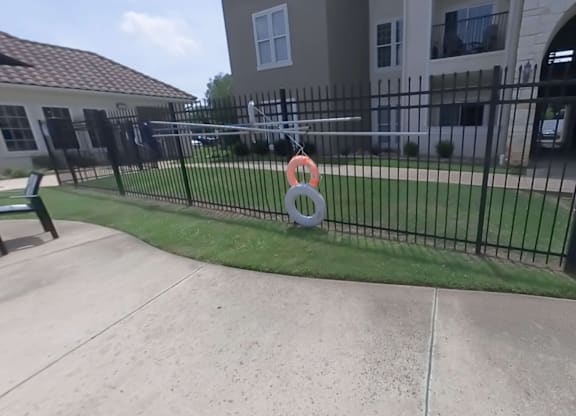 A black fence with a red and white sign in front of a building.