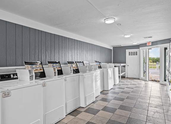 a row of washers and dryers in a laundromat
