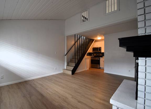 a view of a living room with wood floors and a staircase