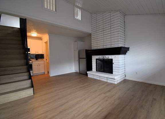 a living room with a fireplace and a wooden floor