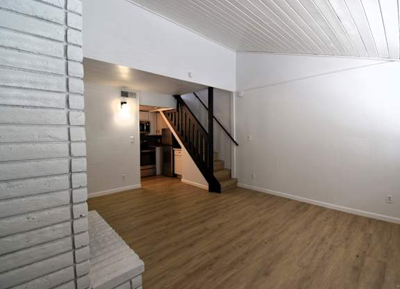a view of a living room with wood floors and a staircase
