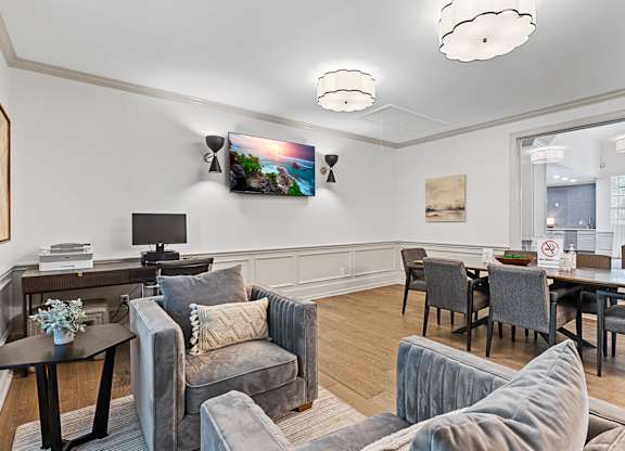 a living room with couches and chairs and a table and a tv