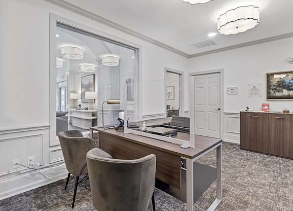 a conference room with a desk and chairs and a mirror
