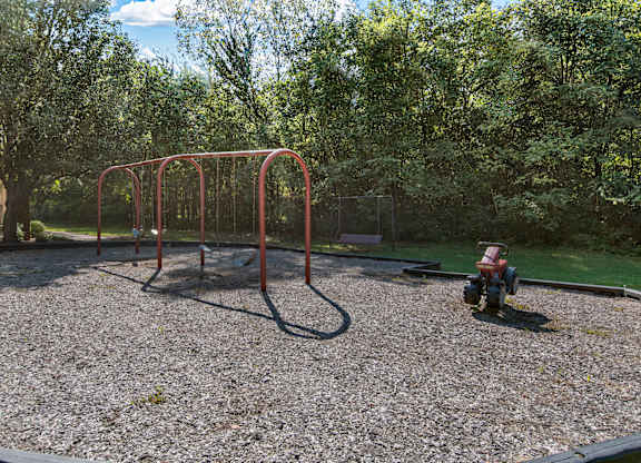 a playground with a swing set and a fire hydrant