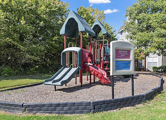 a playground with a red slide and a blue and red