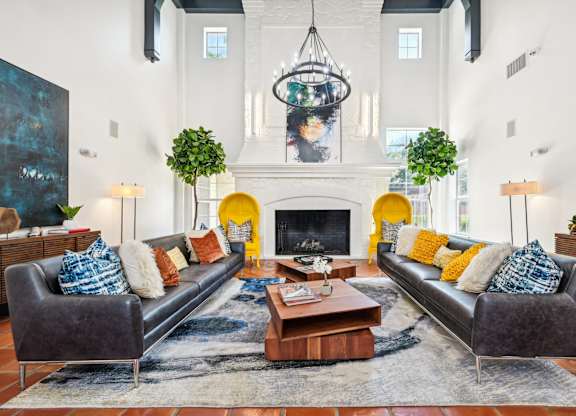 a living room with two leather couches and a fireplace