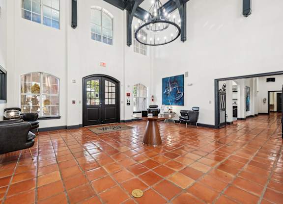 the lobby of a large white building with chairs and a table