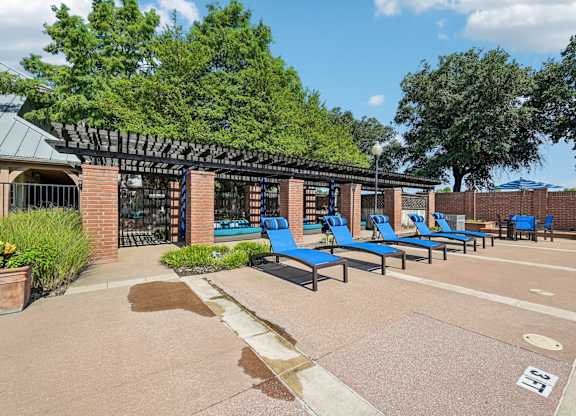 a group of blue lounge chairs in front of a building
