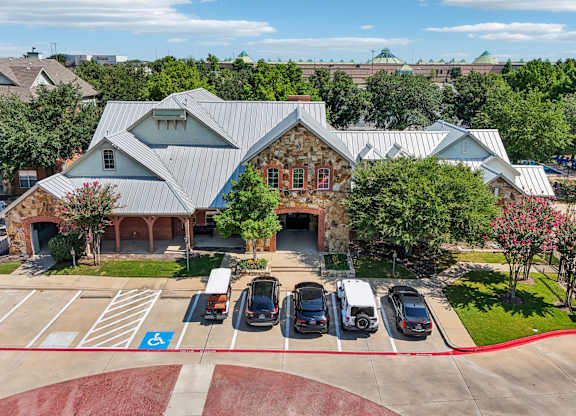 an aerial view of a parking lot with cars in front of a building