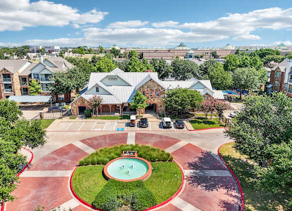an aerial view of a courtyard with a pool and a building with trees