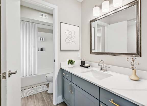 a bathroom with gray cabinets and white countertops