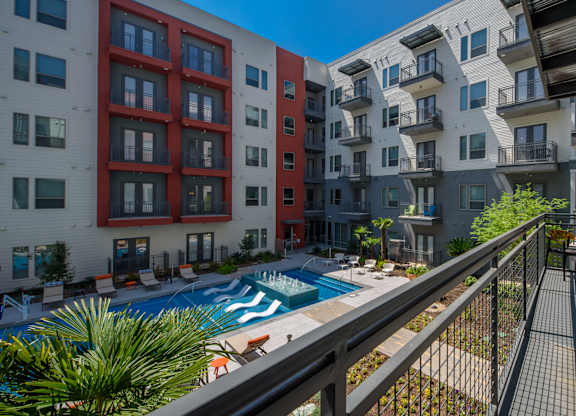 A pool surrounded by apartment buildings.