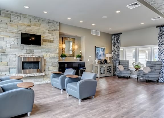 A living room with a stone fireplace and grey couches.