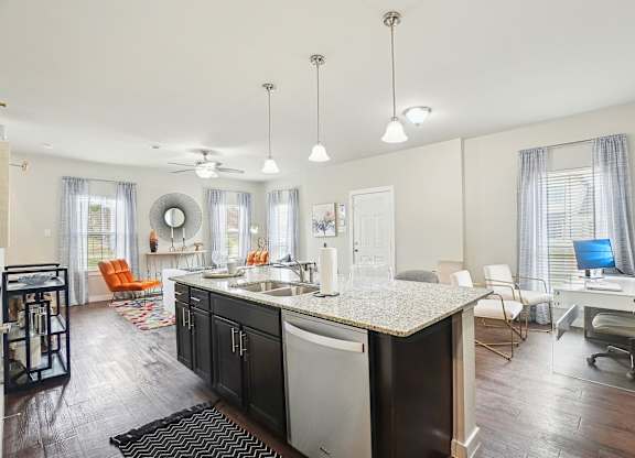 A kitchen with a black and white counter top and a ceiling fan.
