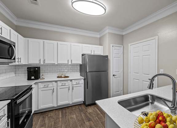 a kitchen with white cabinets and stainless steel appliances