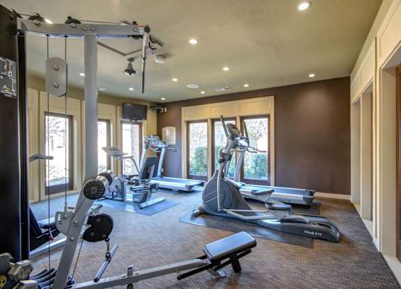 Fitness center with treadmills, elliptical machines, and strength equipment in a bright room