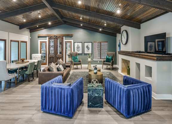 Clubhouse lounge with exposed beam ceiling, plush seating, and open gathering areas.