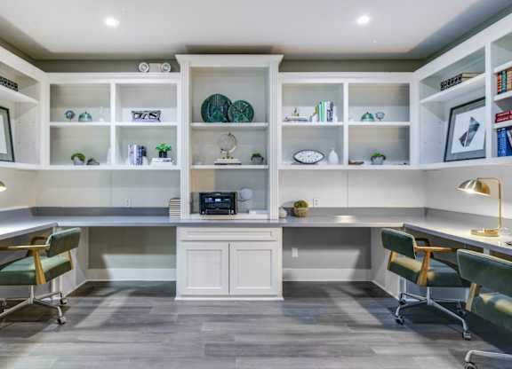 Business center with shared worktable seating, open shelving, and a bright, modern layout.