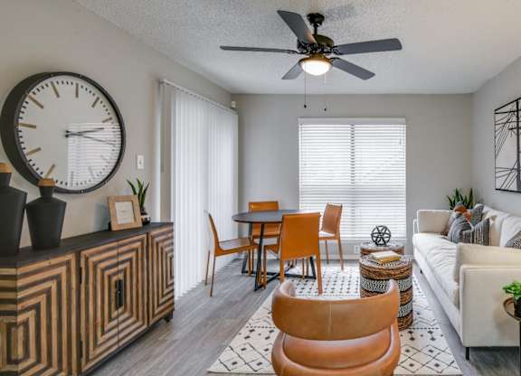 Open living area with round table, ceiling fan, and cozy seating.