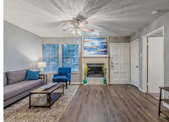 A living room with a fireplace and a painting above it.