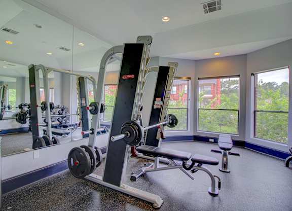 a home gym with weights and a row of windows