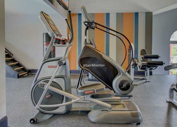 a gym with cardio equipment and a flat screen tv