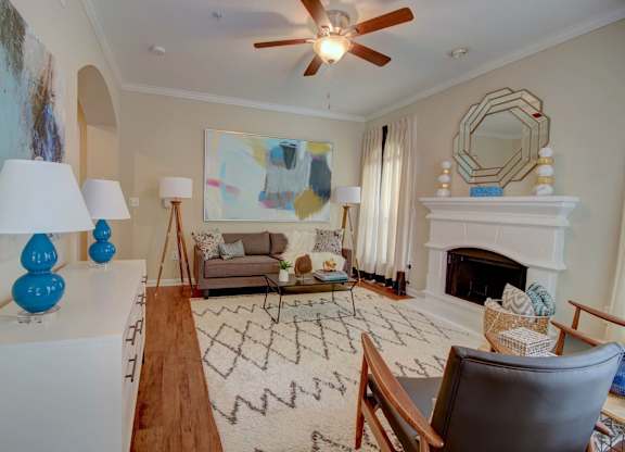 a living room filled with furniture and a ceiling fan