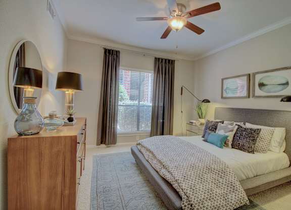 a bedroom with a ceiling fan and a large window