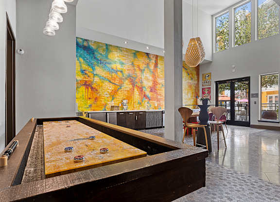 A pool table in a room with a large painting on the wall.