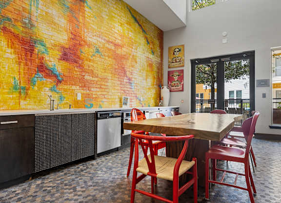 A kitchen with a table and chairs in front of a mural.