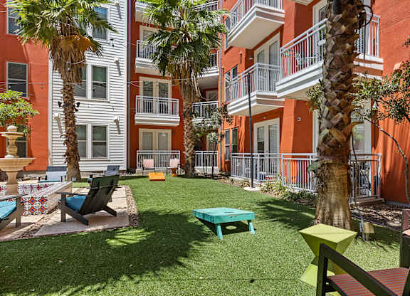 A patio area with a table and chairs surrounded by palm trees.