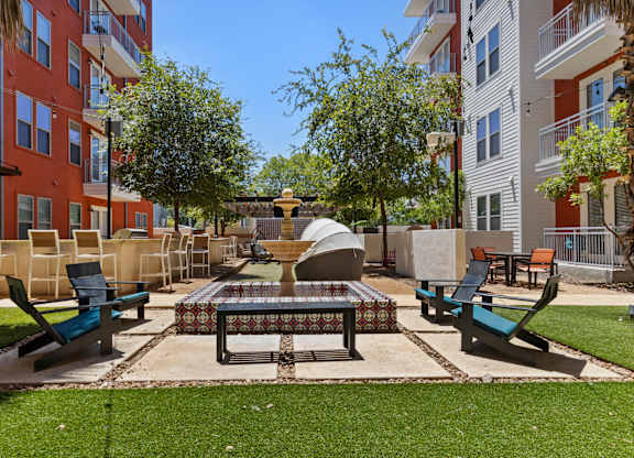 A park area with a table and chairs surrounded by buildings.
