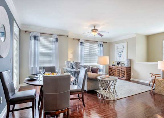 A dining room with a table set for two and a ceiling fan.