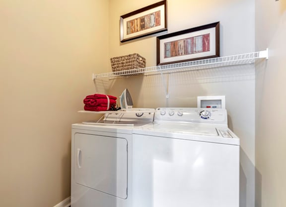 A white washing machine with a red towel on top of it.