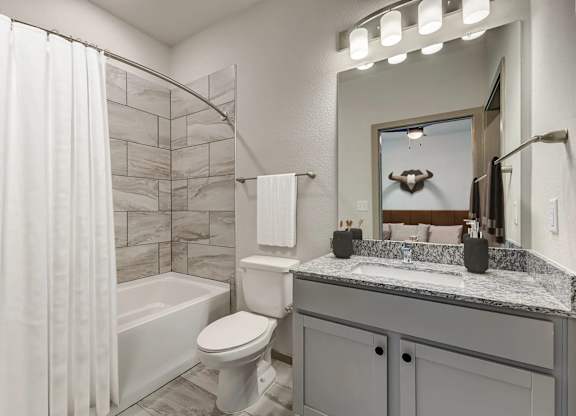 a bathroom with a shower and a toilet and a sink